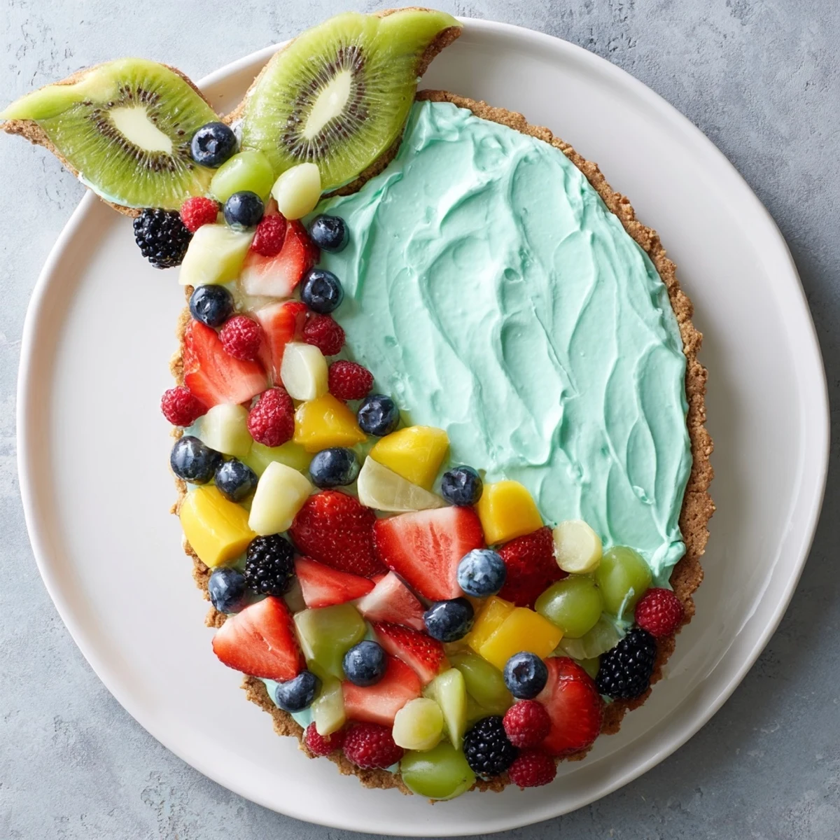 Ein farbenfrohes Unterwasser-Thema: Mermaid Tail Fruit Pizza, dekoriert mit frischen Früchten.