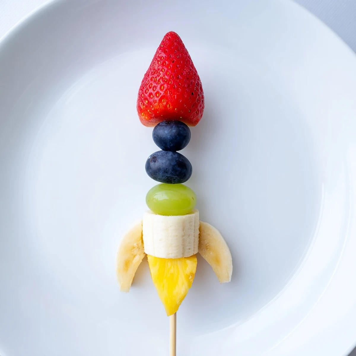 Vibrant Rocket Ship Fruit Skewers with juicy strawberries, pineapple flames, and sweet grape bodies.