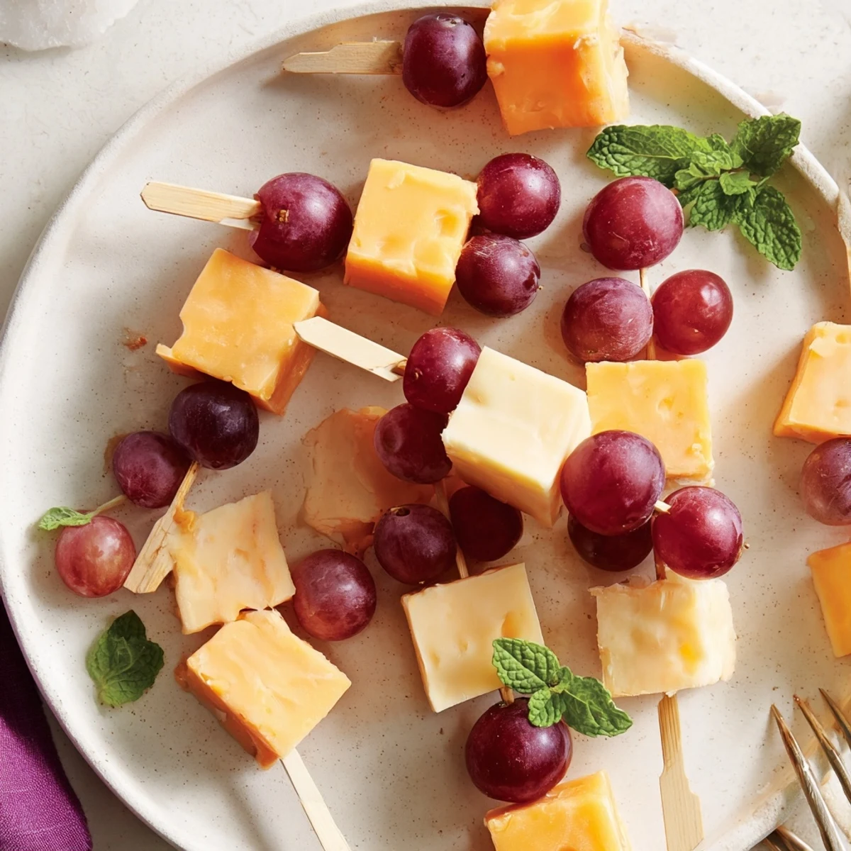 Käse- und Traubenspieße, abwechselnd mit cremigem Käse und süßen, saftigen Trauben garniert.
