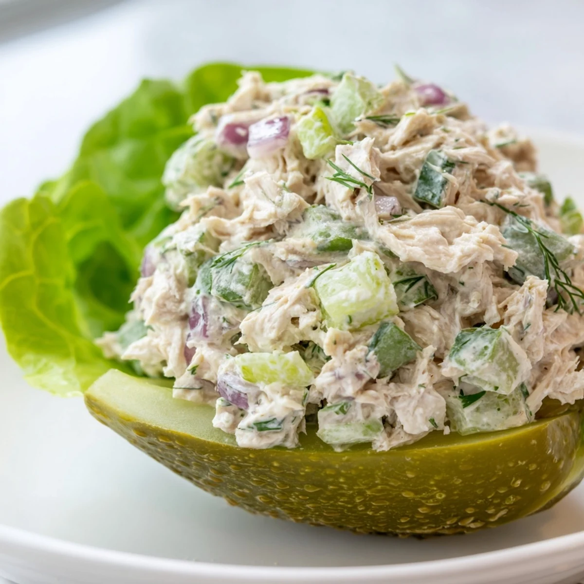 Tangy chicken salad overflowing from hollowed-out pickles, a low-carb Pickle Sandwich delight.
