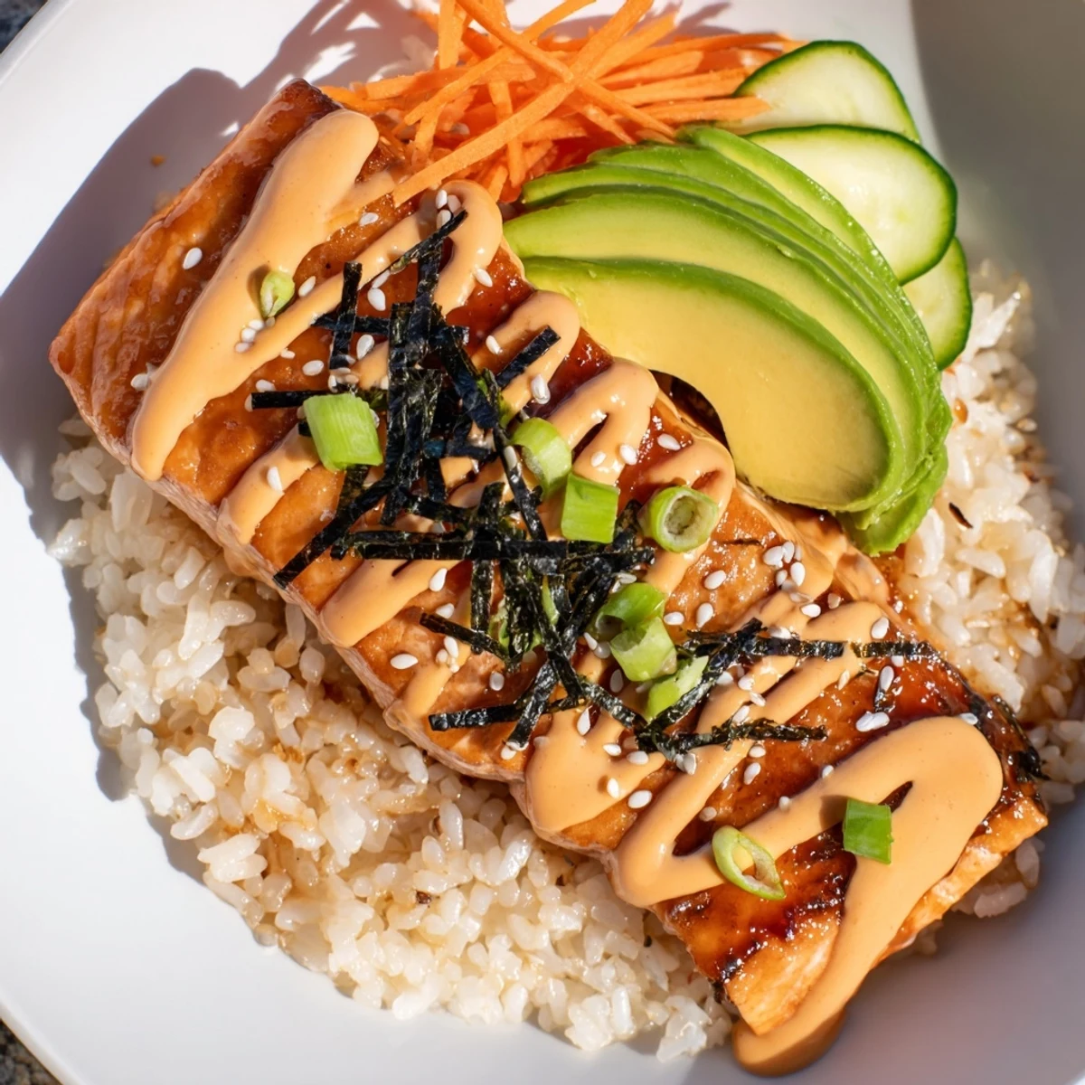 Tender teriyaki salmon rice bowl, a colorful plate of glazed salmon, rice, veggies, and sauce.