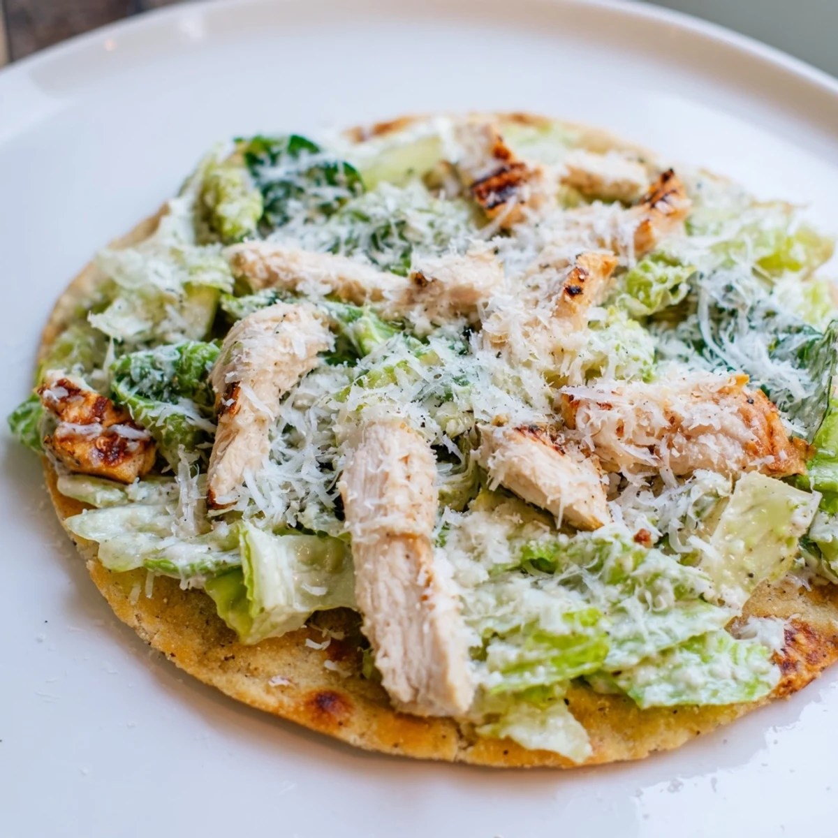 Saftig gegrilltes Hähnchen auf warmer Flatbread, belegt mit Römersalat und cremiger Caesar-Dressing.