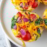Savory Customizable Egg Muffins, fluffy and brimming with colorful peppers, ready for a healthy meal.