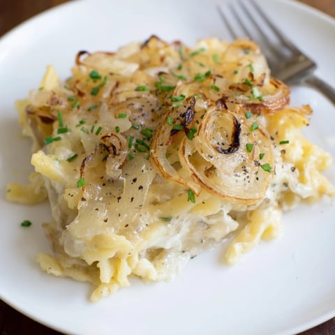 Käse-Nudel-Auflauf mit geschmolzenem Emmentaler und goldbraunen Zwiebeln überbacken.