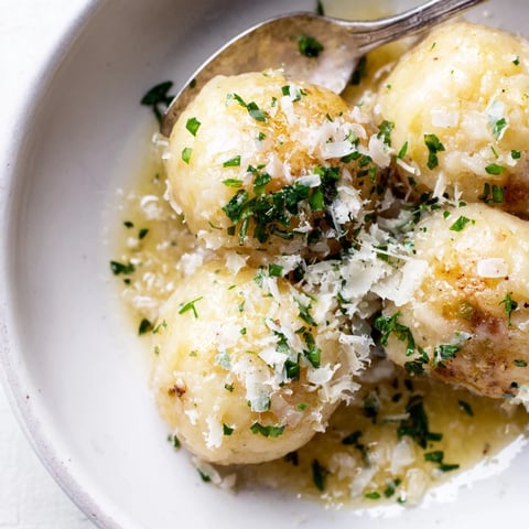 Golden-brown potato dumplings swimming in a rich Parmesan-garlic brown butter sauce; a cozy dinner.