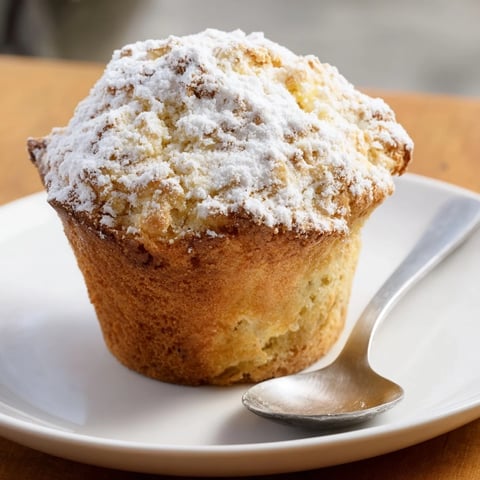 A golden brown Fluffy Quark Muffin, showing its tender interior, perfect for a breakfast treat.