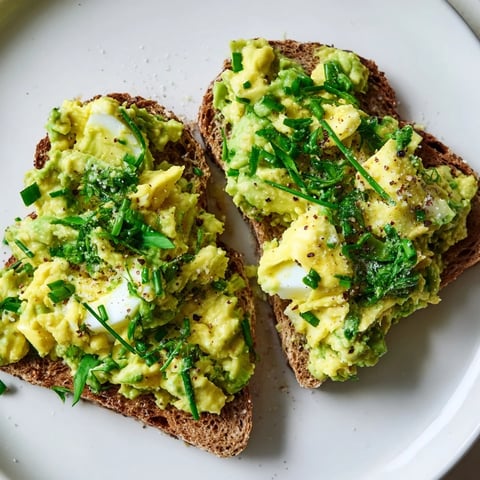 Creamy avocado egg smash on toasted bread, a vibrant and flavorful vegetarian breakfast option.