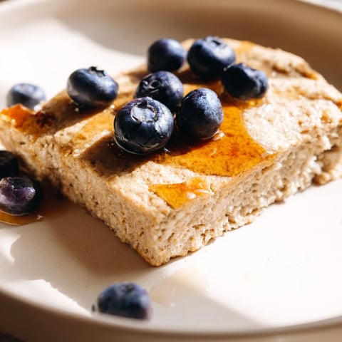 Fluffy Protein Pancake Oats, baked until golden brown, served with fresh blueberries and syrup.