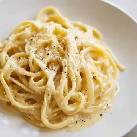 Golden strands of Lazy Girl Three-Ingredient Pasta coated in a rich, creamy Parmesan sauce.