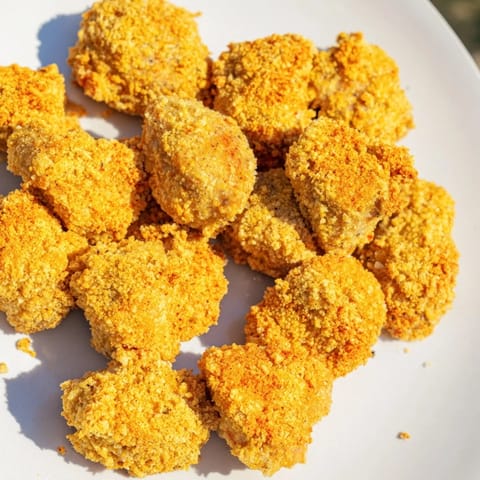 A close-up of delicious Air Fryer Un-Fried Chicken Nuggets, showcasing their crunchy panko crust.