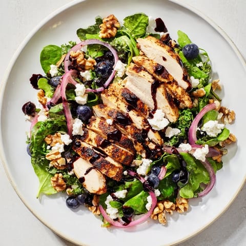 Fresh blueberry goat cheese chicken salad with walnuts and balsamic glaze drizzled over the greens.