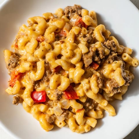 Steaming bowl of One-Pot Chili Mac: a close-up shows melted cheese and flavorful sauce.