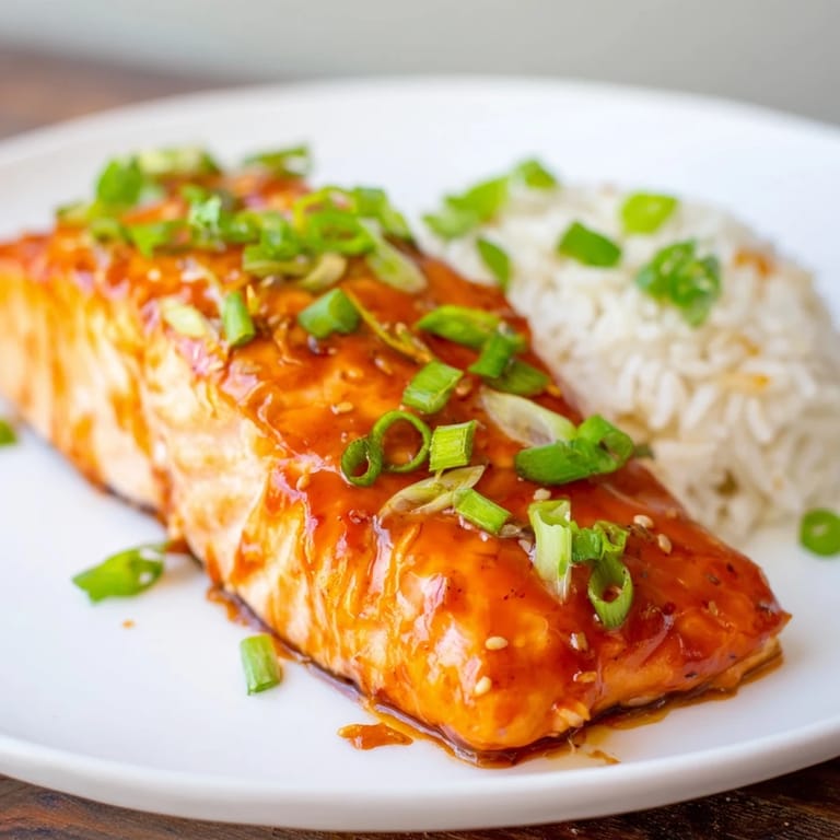 Seared Sticky Orange Salmon with a glazed, caramelized top, on a bed of rice, Asian-inspired meal.