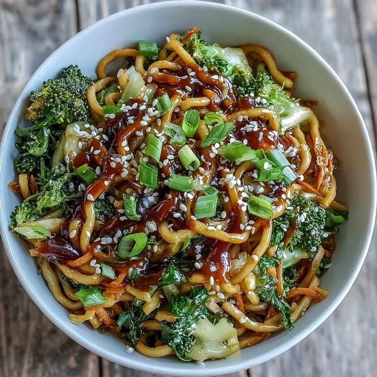 Sättigende Teriyaki-Nudelschüssel mit Eiernudeln, gedünstetem Brokkoli und Karotten, verfeinert mit duftenden Sesamsamen und frischen Lauchzwiebeln.
