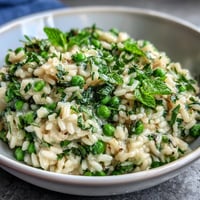 Frischer Erbsen-Minze-Risotto mit Parmesan, cremig und mit Zitronenabrieb.